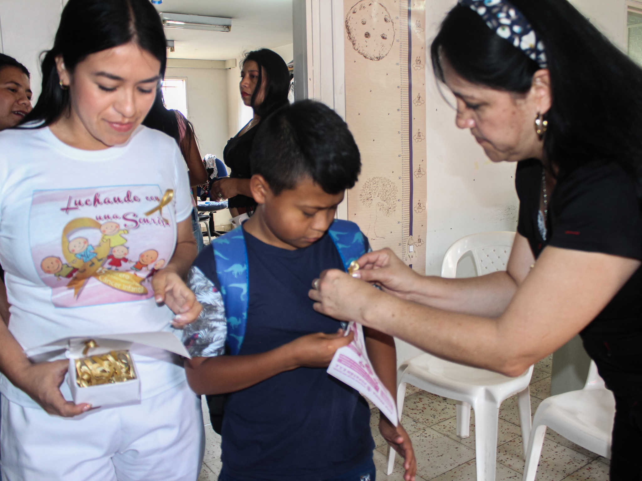Doctores y auxuliares repartiendo los listones dorados